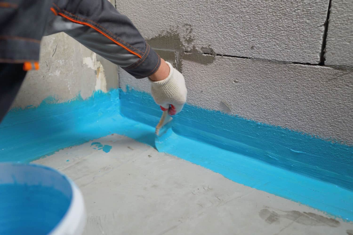 Cover-the-concrete-wall-with-a-cement-polymer-waterproofing-membrane on the foundation