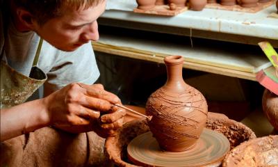 potter making intricate designs on the pot